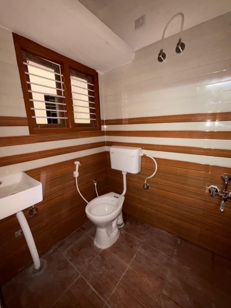 SLN Homes attached modern tiled bathroom with sanitary fittings and washbasin